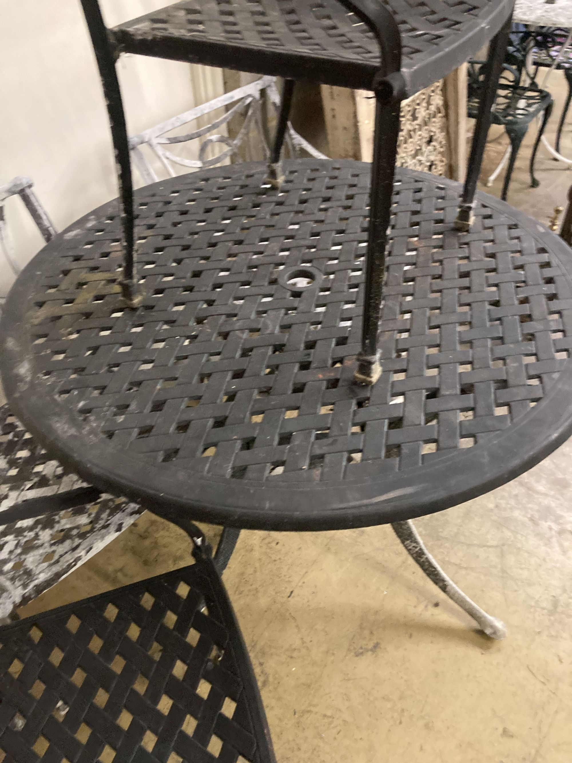 A painted aluminium circular garden table, 106cm diameter together with four matching elbow chairs